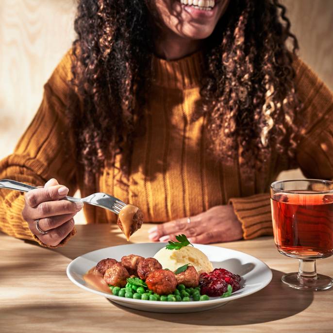 Osoba jí masové kuličky v restauraci IKEA.